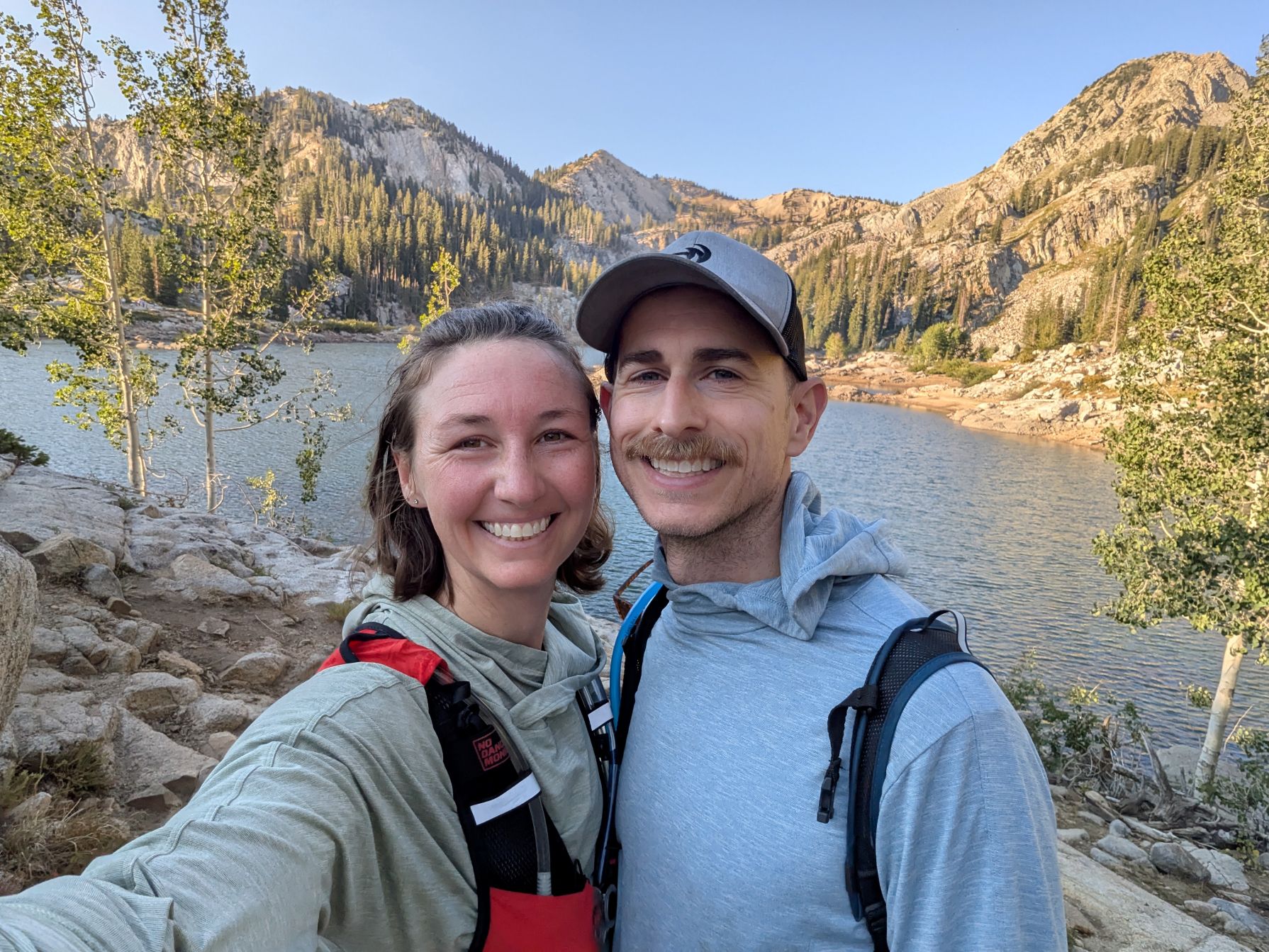 Two hikers at Lake Mary on Alta-Brighton Lakes Loop